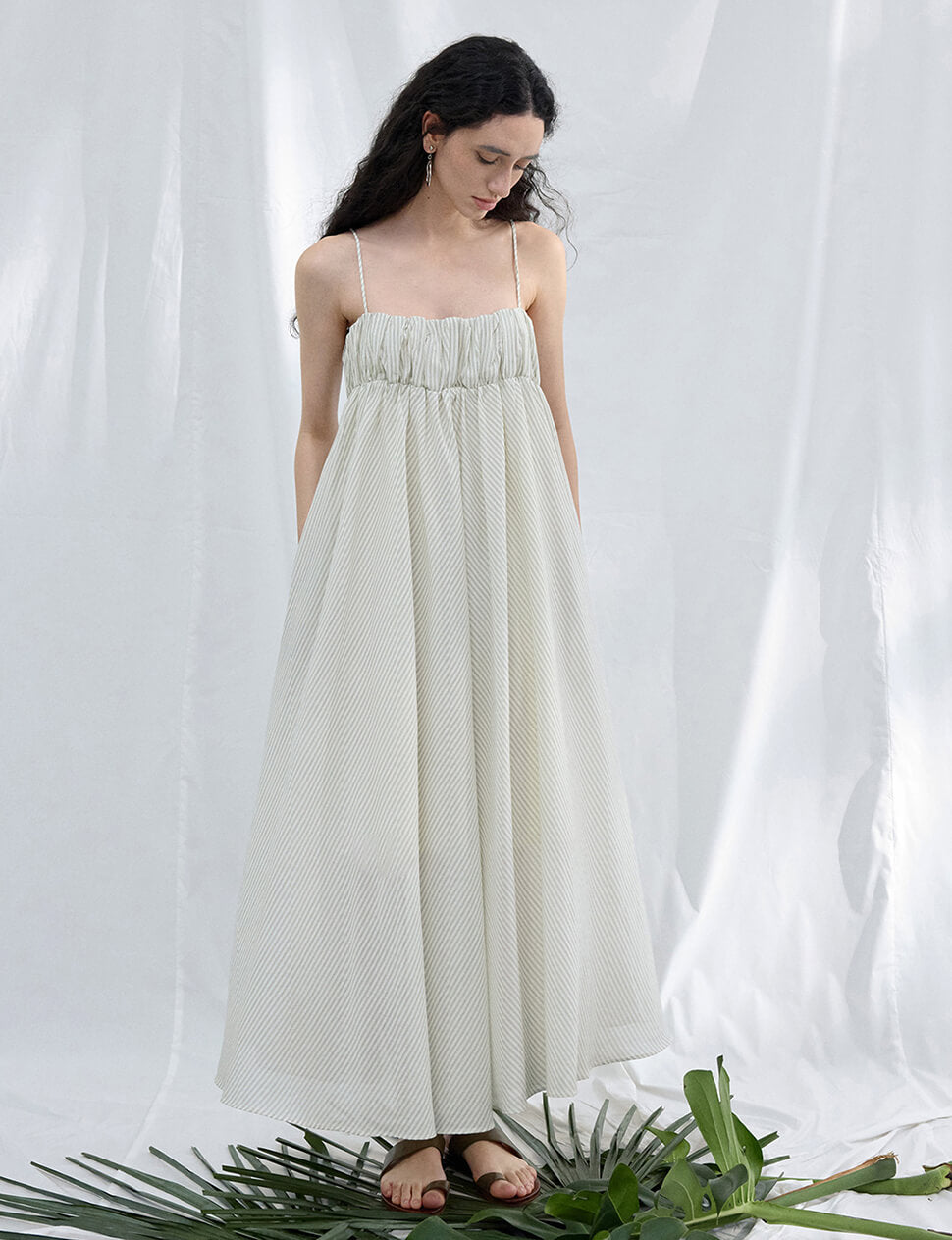 cream empire line dress Model wearing a strapless cream empire line flolength evening dress with metallic gold embroidery Stock Photo
